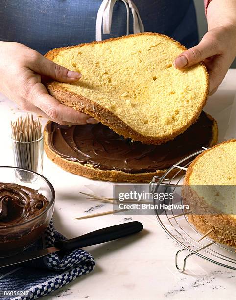 person layering cake - sponge cake stock-fotos und bilder