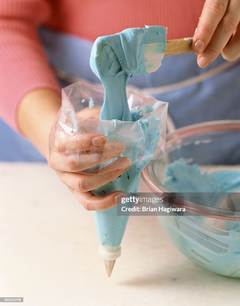 Person filling pastry bag with icing