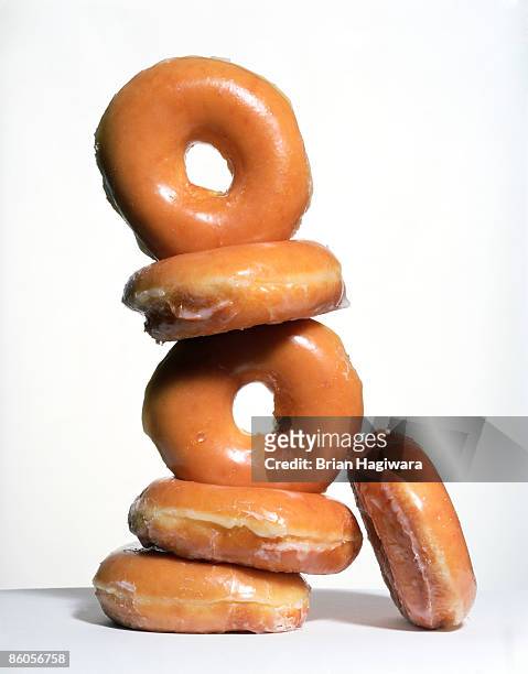 stack of glazed donuts - donut stock-fotos und bilder