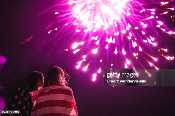 multi-ethnic women taking photos of fireworks display in night sky - american flag fireworks stock pictures, royalty-free photos & images