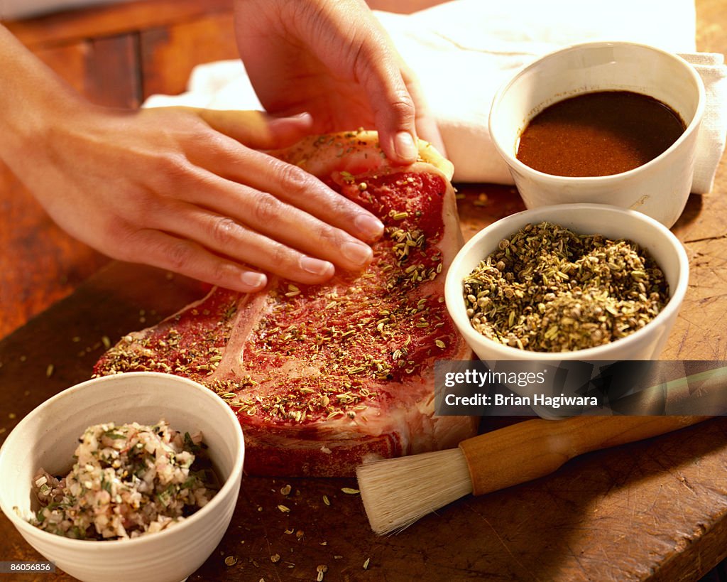 Person seasoning porterhouse steak