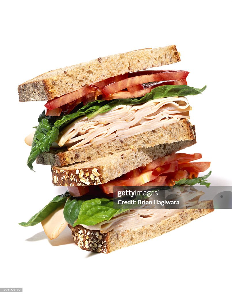 Layered turkey sandwich with lettuce and tomato