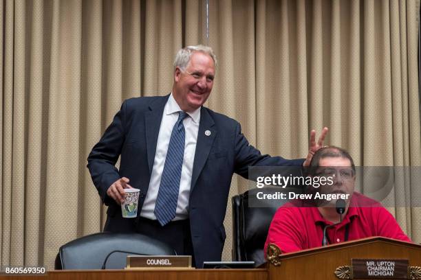 Rep. John Shimkus holds up bunny ear fingers behind a a technician testing the microphones before the start of a House Energy and Commerce Committee...