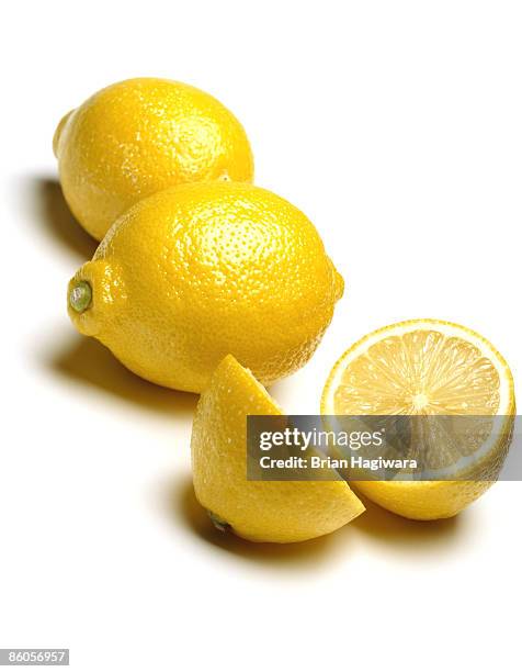 whole and halved lemons on white - lemon stockfoto's en -beelden