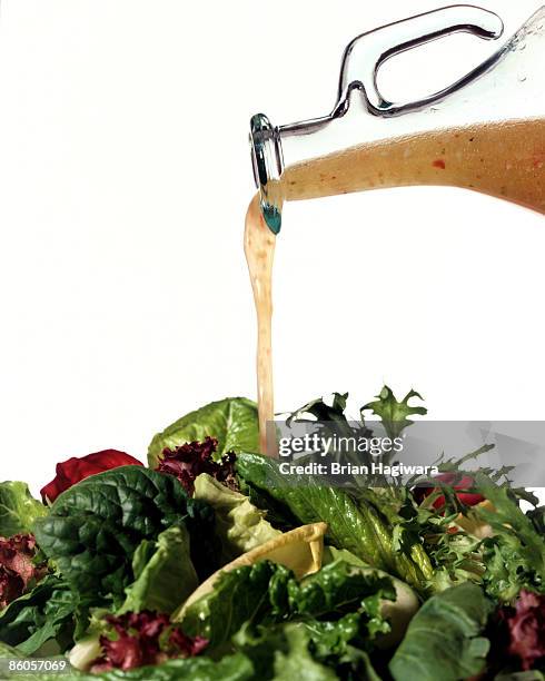 salad greens with vinaigrette dressing - aliño para la ensalada fotografías e imágenes de stock