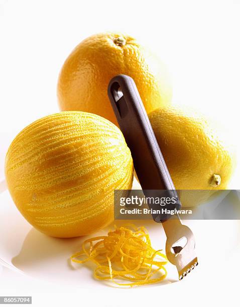 zesting orange and lemon - zitruszeste stock-fotos und bilder