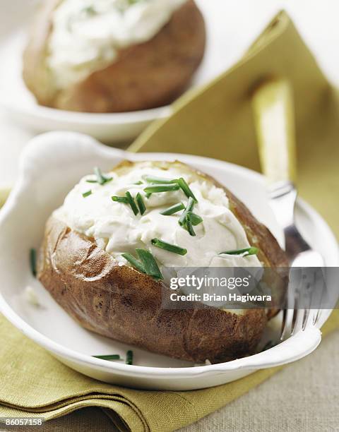 baked potato with sour cream and chives - gepofte-aardappel stockfoto's en -beelden