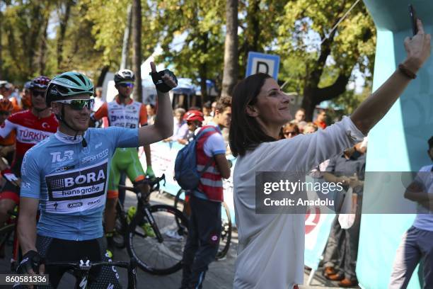 Announcer of the lap Basak Koc takes a selfie with Irish cyclist and general classification leader Sam Bennett of Bora-Hansgrohe ahead of the next...