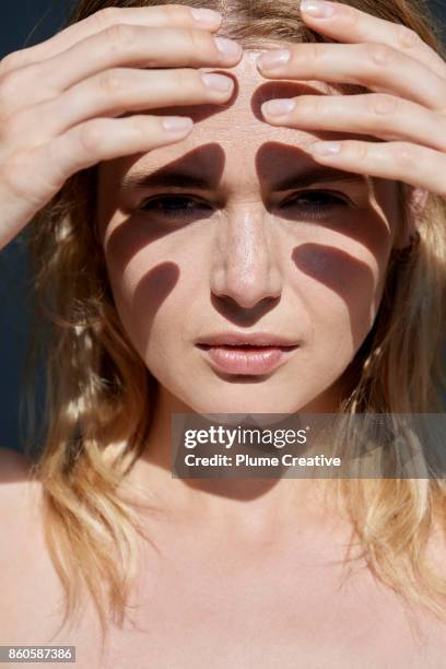 woman shielding eyes from sun - squinting stock pictures, royalty-free photos & images