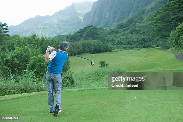 senior man swinging golf club, rear view - golf short iron stock pictures, royalty-free photos & images