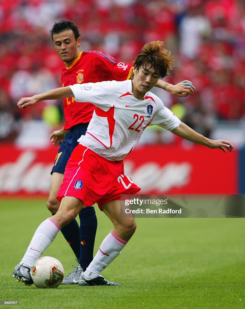 Chong Gug Song of South Korea shields the ball from Luis Enrique of