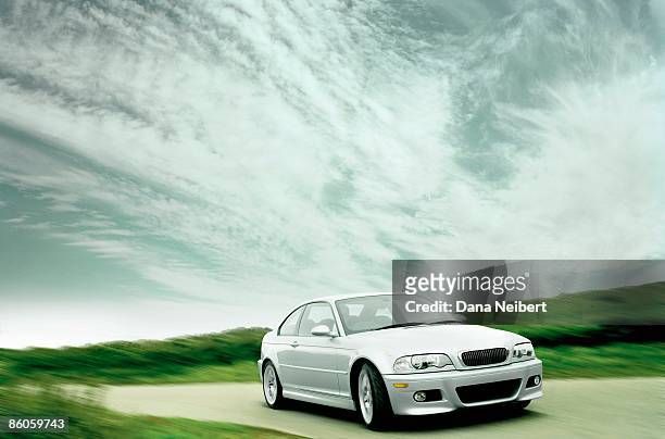 car driving on road with clouds - automobile foto e immagini stock