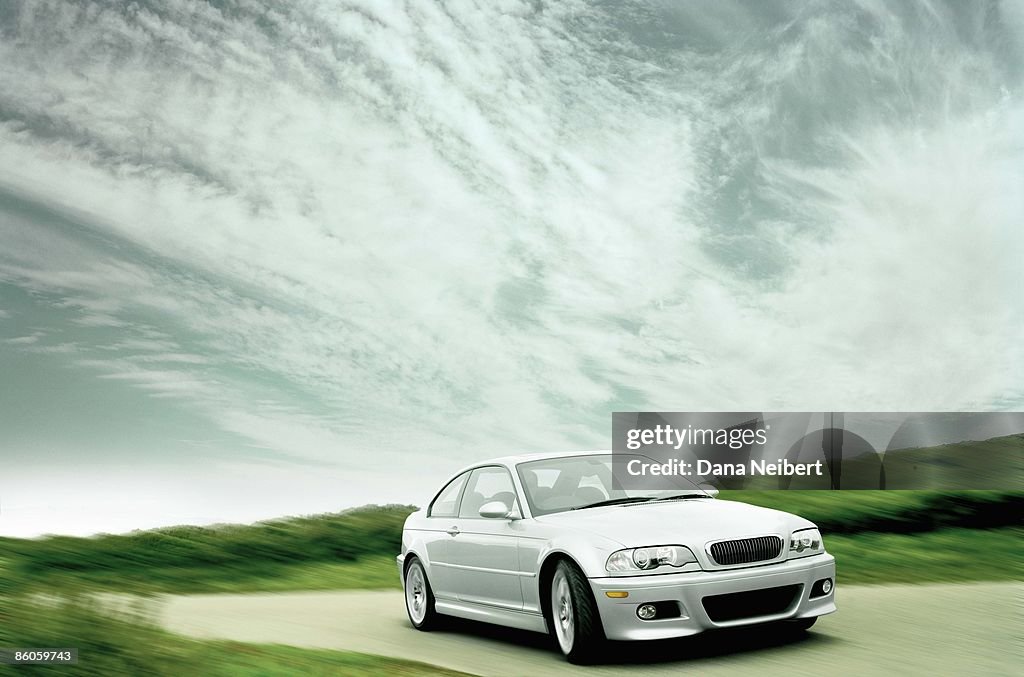 Car driving on road with clouds