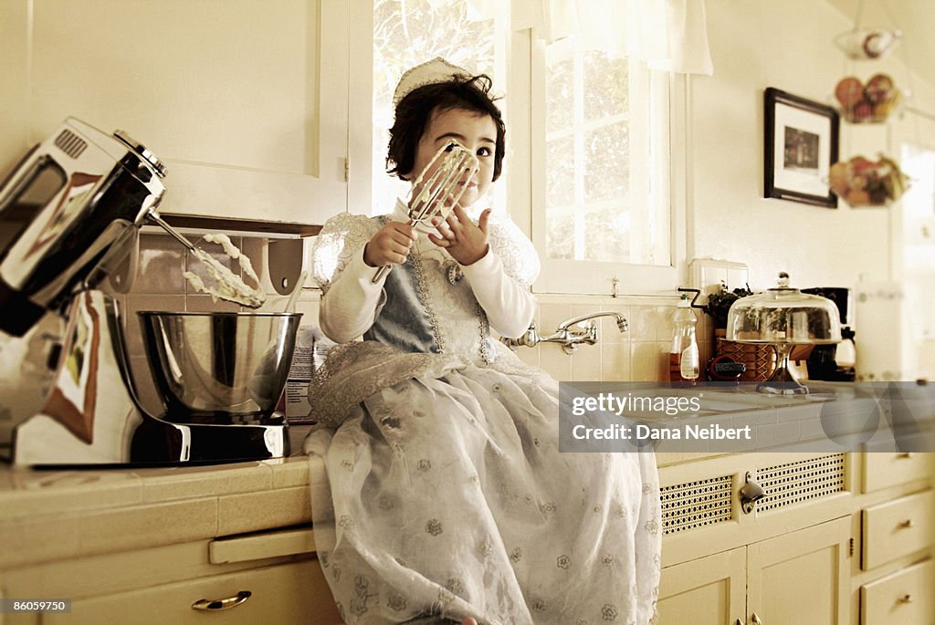 Girl eating batter from mixer