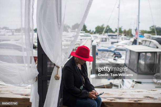 Stacey Grace-Moore of Alexandria, Va., sits near docked boats during the opening ceremony of the Wharf complex along Maine Avenue, SW, on October 12,...