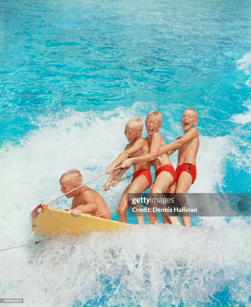 Boys riding on a water sled