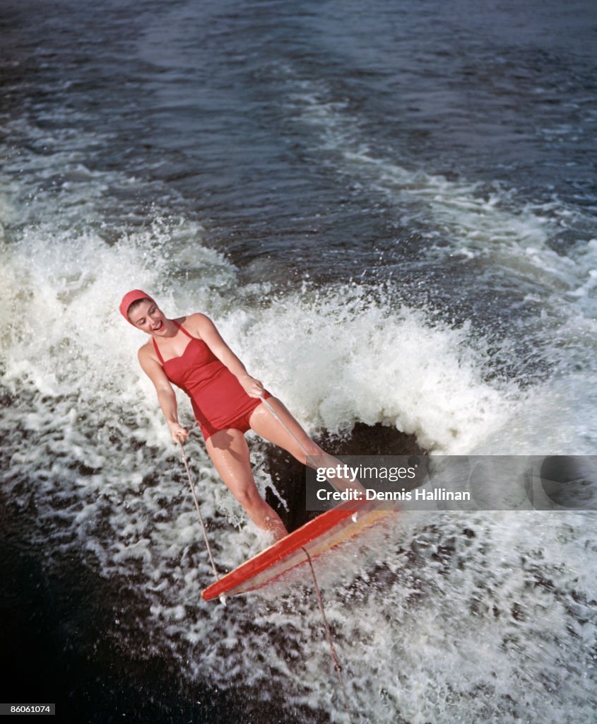 Happy retro water skier riding water sled