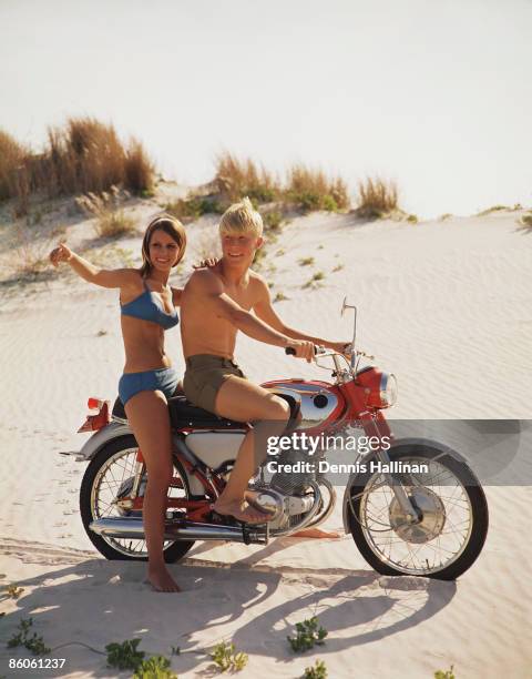 Couple riding motorcycle on beach