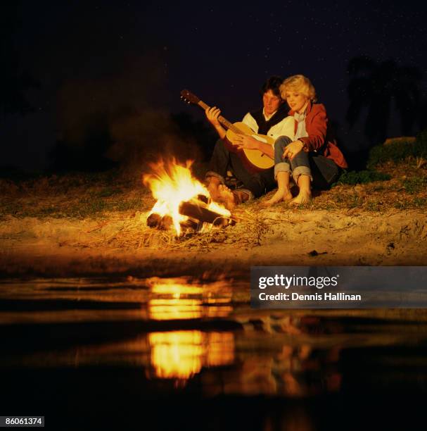 Couple sitting by campfire