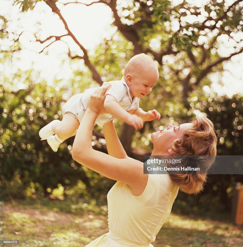 Mother lifting baby
