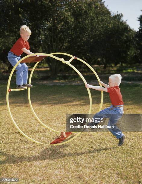 Brothers playing outside with giant wheel toy