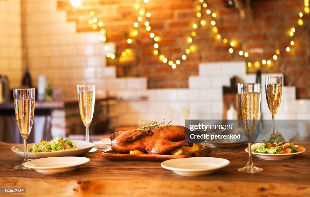 Winter holiday family dinner with roast poultry and champagne