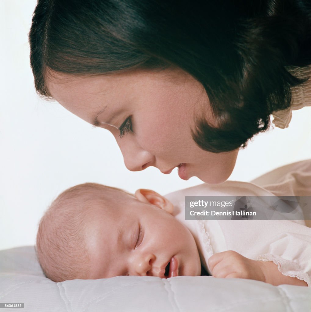 Mother whispering to sleeping baby