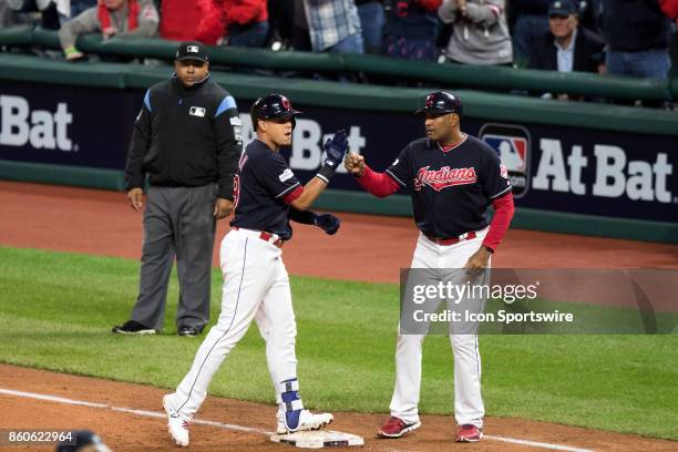 Cleveland Indians infielder Giovanny Urshela is congratulated by Cleveland Indians first base coach Sandy Alomar Jr. After driving in a run during...