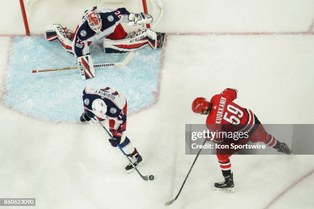 Columbus Blue Jackets Center Brandon Dubinsky defends a shot by Carolina Hurricanes Winger Janne Kuokkanen in a game between the Columbus Blue...