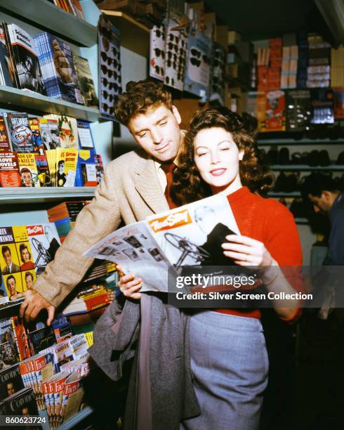 American actors Burt Lancaster and Ava Gardner read a magazine in a newstand on the set of 'The Killers' , Universal City, California, 1946.