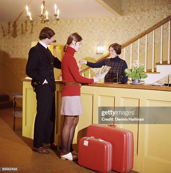 Couple doing check-in at hotel reception desk Couple doing check-in at hotel reception desk