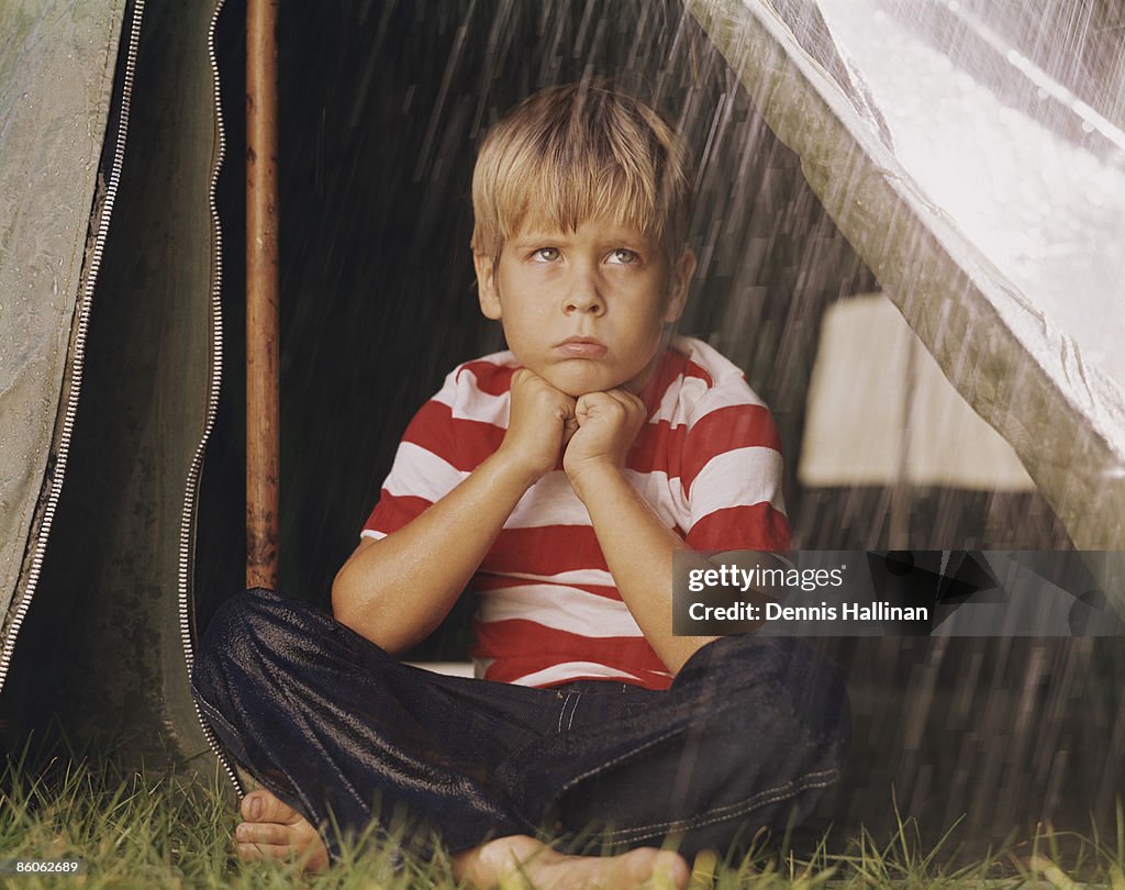 Sad Young Boy Camping in the Rain