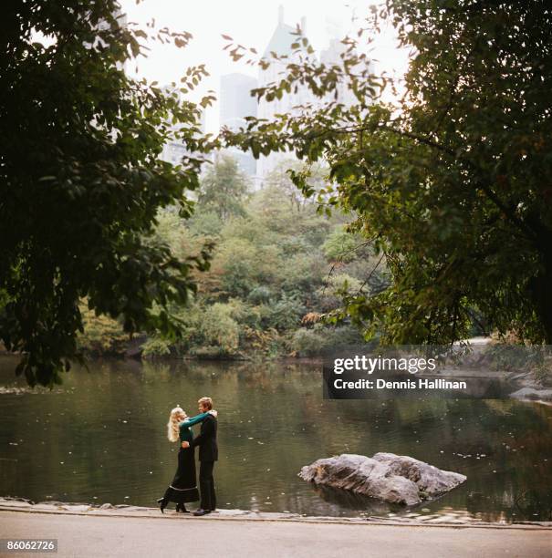 Couple embracing by pond in park