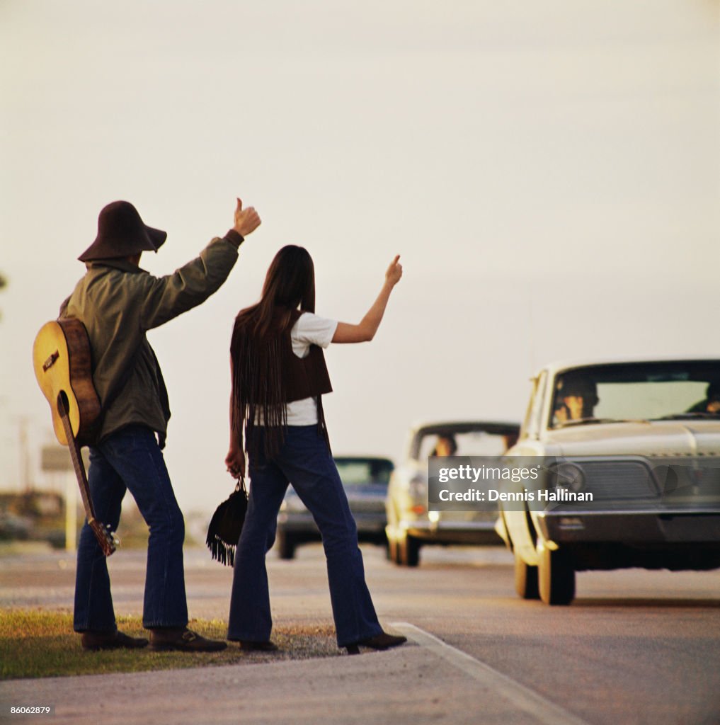 Musicians hitchhiking on highway