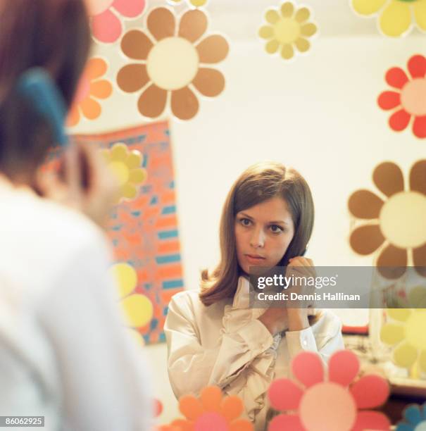 Woman combing hair while looking in mirror