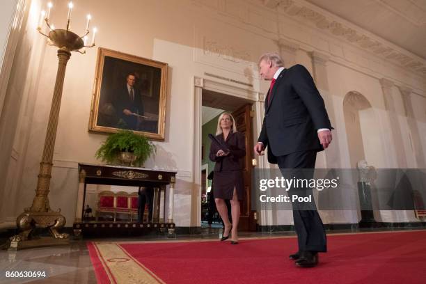 President Donald Trump walks from the Green Room into the Cross Hall to the East Room, with Kirstjen Nielsen , before announcing her as his nominee...