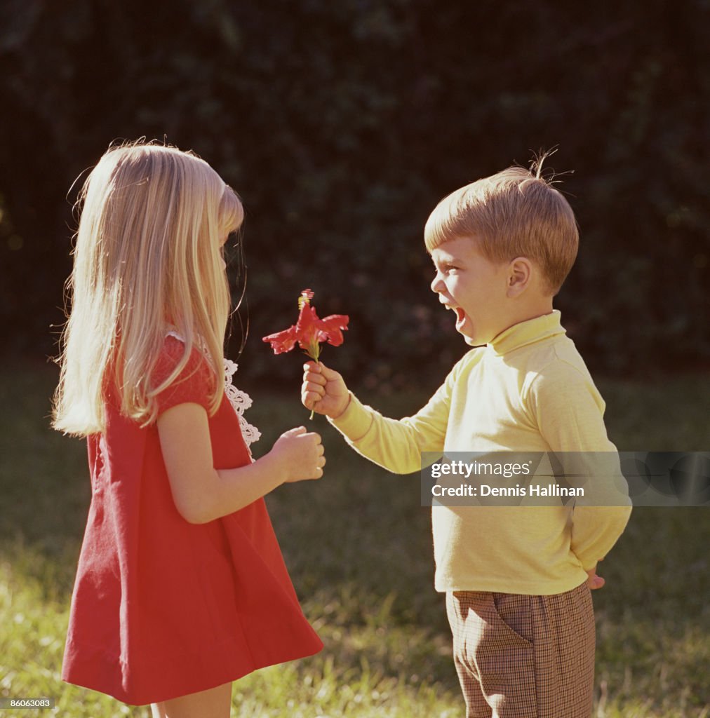 Happy boy giving flower to girl