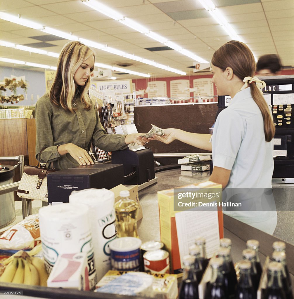 Woman paying cashier at grocery store