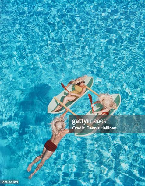 Retro family relaxing in pool floats wearing straw hats