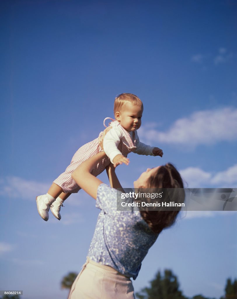 Mother lifting baby up