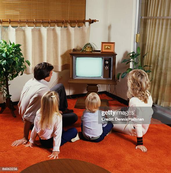 Family on floor watching television Family on floor watching television