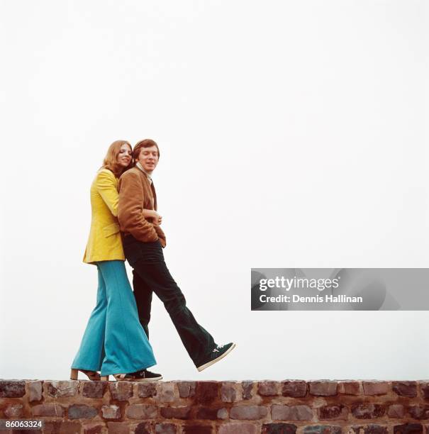 Couple walks on brick retaining wall