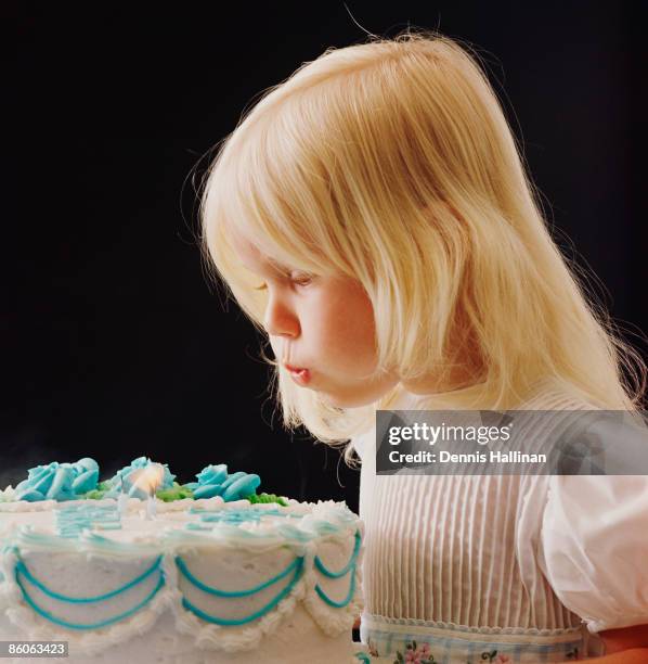 Girl blowing candles on birthday cake