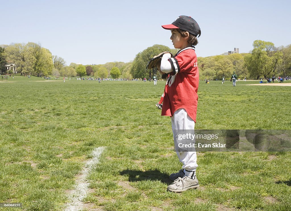 Side view of boy holding baseball glove