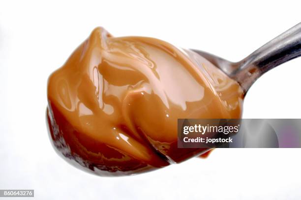 a spoon with milk caramel spread better nown as dulce de leche - プリン ストックフォトと画像