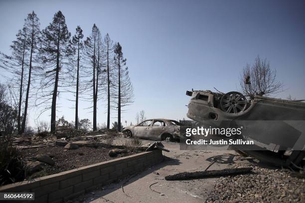 An overturned car sits in front of homes that were destroyed by the Tubbs Fire on October 12, 2017 in Santa Rosa, California. Twenty four people have...