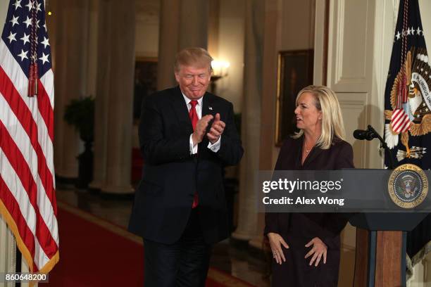 President Donald Trump applauds as White House Deputy Chief of Staff Kirstjen Nielsen looks on during a nomination announcement at the East Room of...