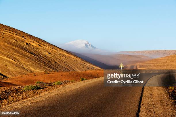 the m'goun mountain (4,071 meters) emerging from the morning mist - atlas maroc stock-fotos und bilder