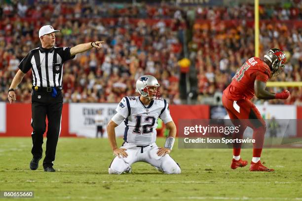 New England Patriots quarterback Tom Brady looks on as Tampa Bay Buccaneers defensive end Robert Ayers Jr. Celebrates during an NFL football game...