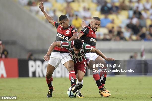 Marcio Araujo and Romulo of Flamengo battles for the ball with Douglas of Fluminense during the match between Flamengo and Fluminense as part of...